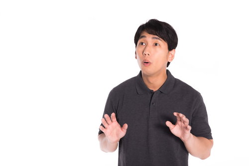 突然の出来事に慌てて両手を上げる男性の驚きと動揺