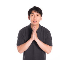 手を合わせて感謝する男性の合掌姿勢、真摯な表情で謝罪とお礼を表現の写真