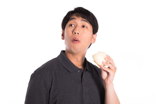 豚まんを頬張る男性の驚きの表情