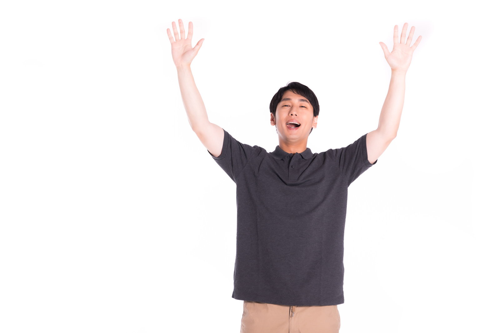 グレーのTシャツを着た男性が両手を高く上げて大きく口を開けて喜んでいる［モデル：大川竜弥］