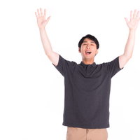 グレーのTシャツ姿で両手を上げて喜ぶ男性の写真