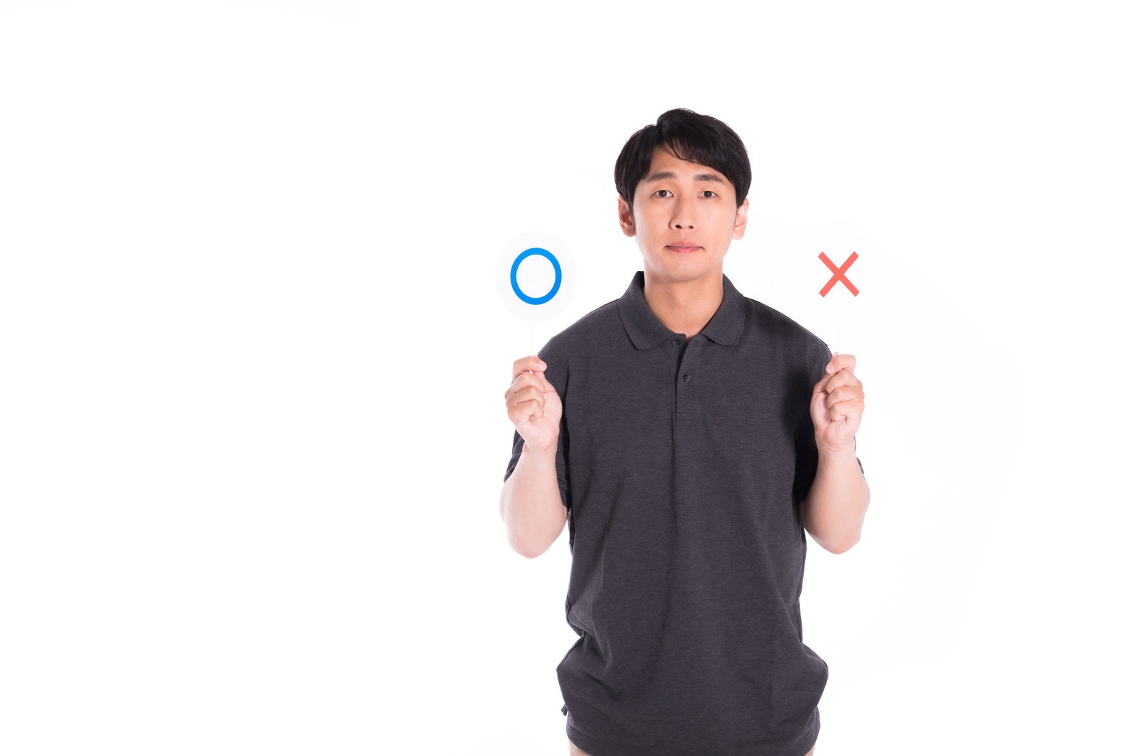 両手に○と×のマークを持ってジャッジする表情の男性［モデル：大川竜弥］