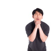 両手を合わせて懺悔する男性、真剣な表情で祈りのポーズの写真