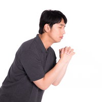 両手を合わせて目を閉じ祈願する男性のポートレートの写真
