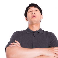 腕組みして上から目線で見下す男性の軽蔑的な態度の写真