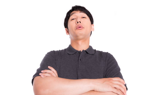 腕組みして上から目線で見下す男性の軽蔑的な態度