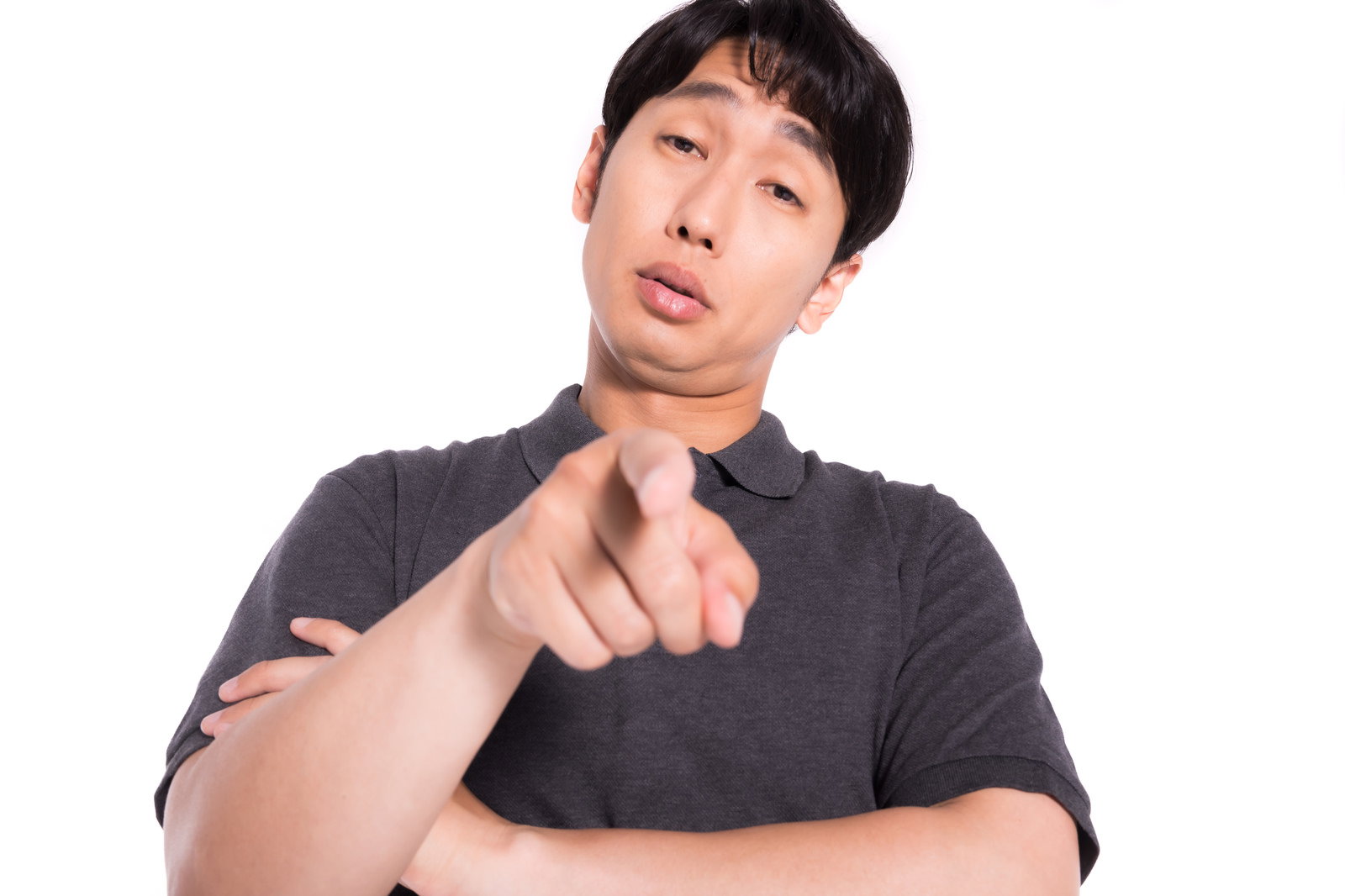 A man in a gray shirt pointing his finger with an arrogant expression