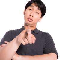 指を差してマウントをとってくる男性の蔑むような表情の写真