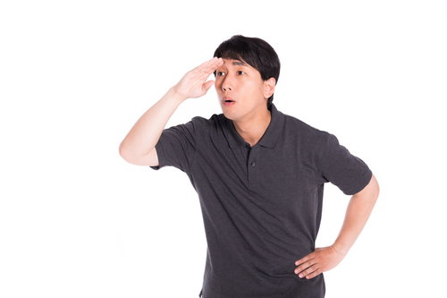 遠くを見渡す男性が手をかざすビジネスポーズ