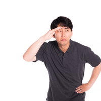 訝し気に周りを見渡し、手をかざして確認する男性の写真