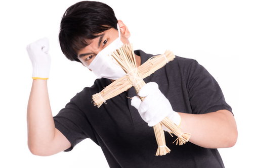 藁人形に恨みを込める男性