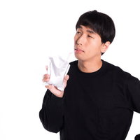 ティッシュを手に困惑する男性の表情の写真