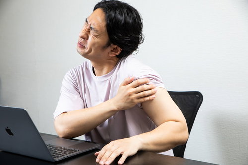 デスクワークで左腕の様子がおかしい男性、肩の痛みで苦しむ