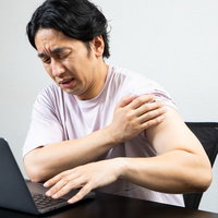 ワクチン接種で痛みを感じてしかめっ面の男性の写真