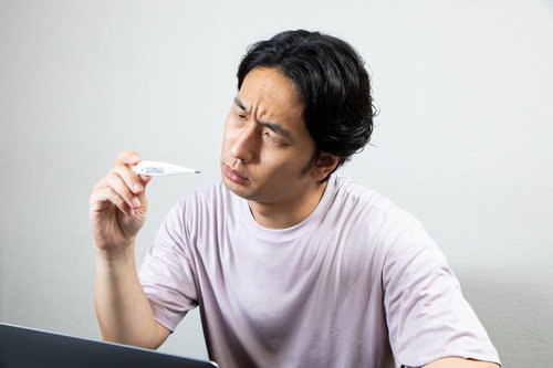 体温計の数値を凝視してしかめっ面になる男性