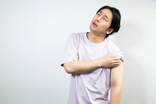 ワクチン注射の鈍い痛みに顔をしかめる男性