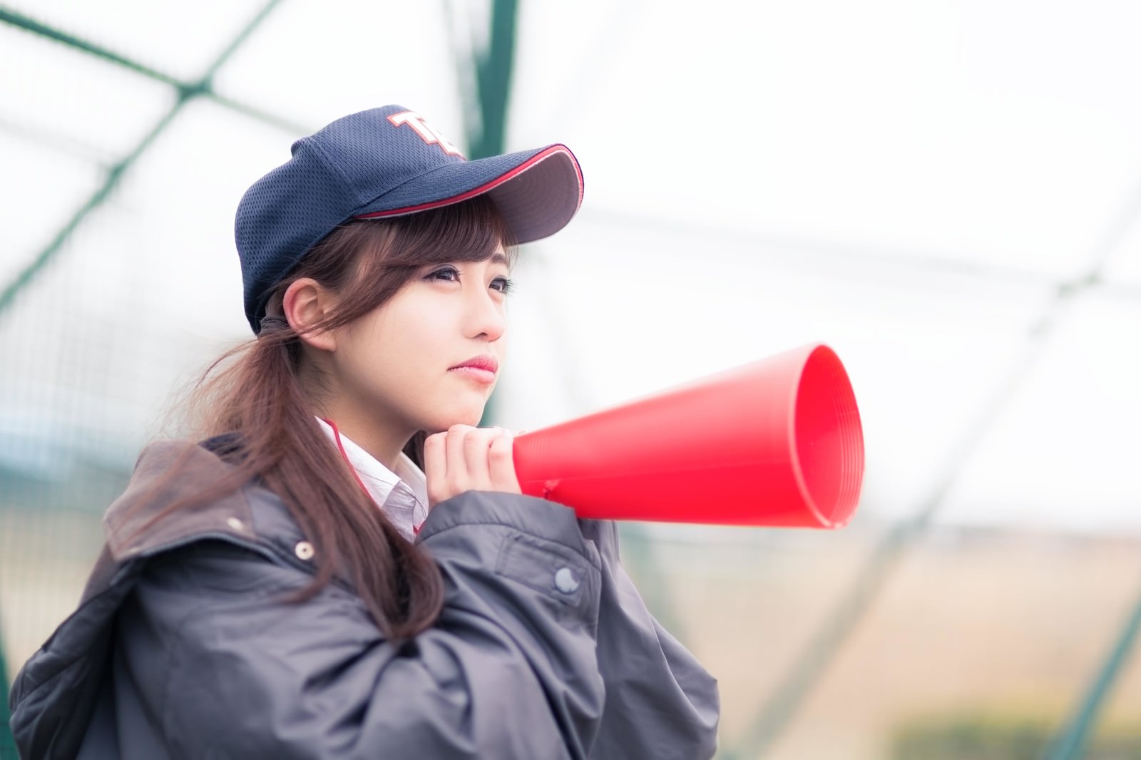 赤いメガホンで応援する女子高生［モデル：河村友歌］