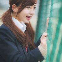 バックネット裏から声援を送る女子高生の写真