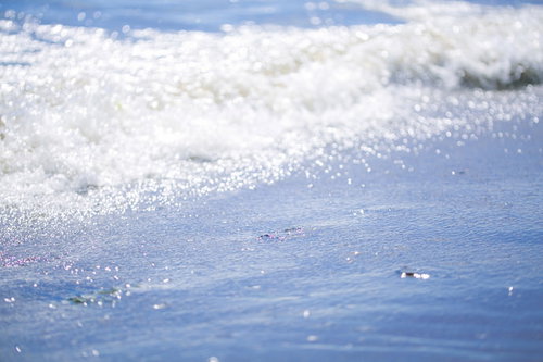 寄せては返す波が砂浜に打ち寄せる海辺の風景