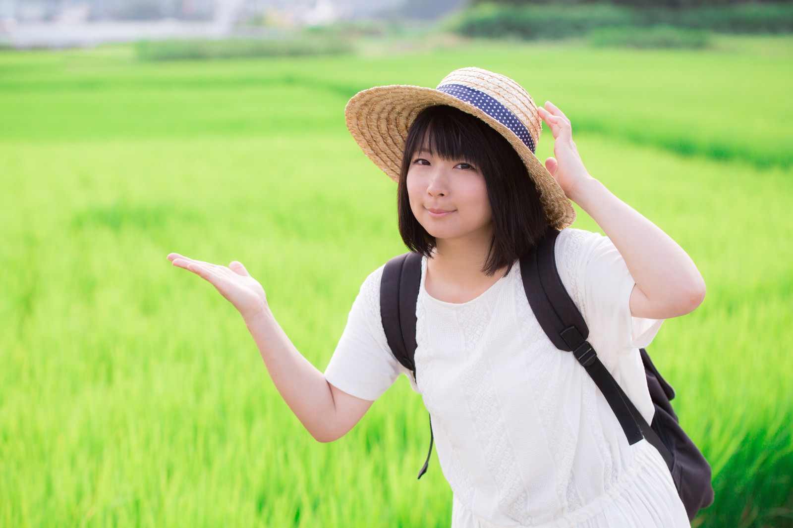 緑の田んぼで麦わら帽をかぶった女性［モデル：にゃるる］