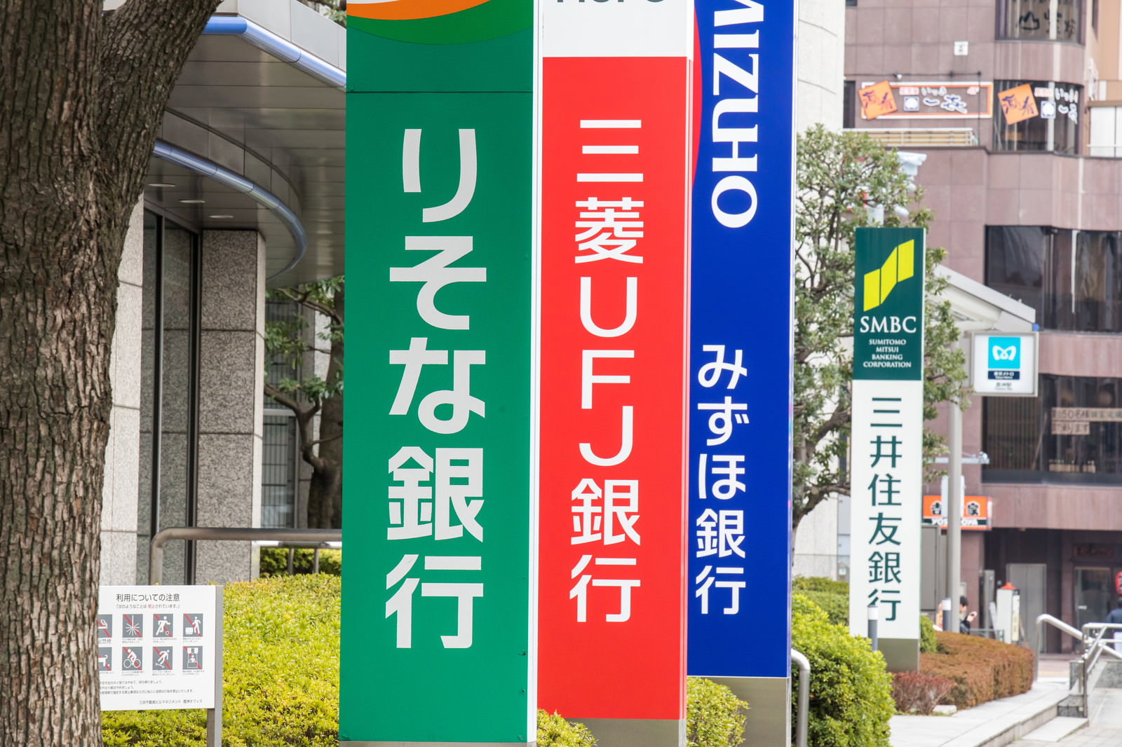 りそな銀行、三菱UFJ銀行、みずほ銀行の看板が縦に並んで設置されている様子