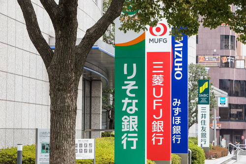 銀行や金融系のニュースが話題になると使われるメガバンクの看板と街路樹