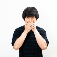 息苦しさに口を覆う驚く男性の衝撃的なリアクションの写真