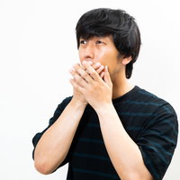 年収低すぎと知って驚く素振りを見せるエキストラの男性の写真