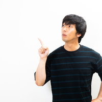 僕のオススメはこれ！と指をさす驚く若い男性の写真