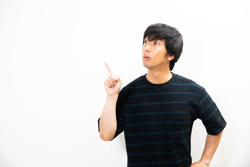 僕のオススメはこれ！と指をさす驚く若い男性