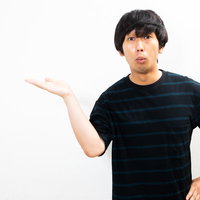 口をすぼめて説明する男性の写真