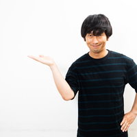 黒いTシャツの男性による怪しい薄ら笑いの案内ポーズの写真