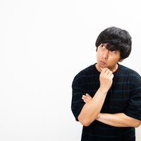 考えごとをして悩みを抱える男性の表情と仕草の写真