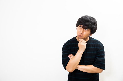 考えごとをして悩みを抱える男性の表情と仕草