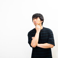 顎に手を当てて考え込む男性の写真