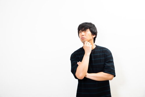 顎に手を当てて考え込む男性