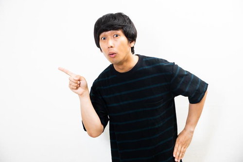 指を指して驚き顔の男性