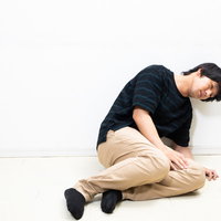 ぐったり倒れ込む具合の悪い男性、疲労と不安を表現したメンタルヘルスの写真