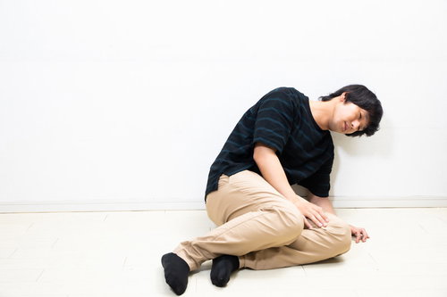 ぐったり倒れ込む具合の悪い男性、疲労と不安を表現したメンタルヘルス