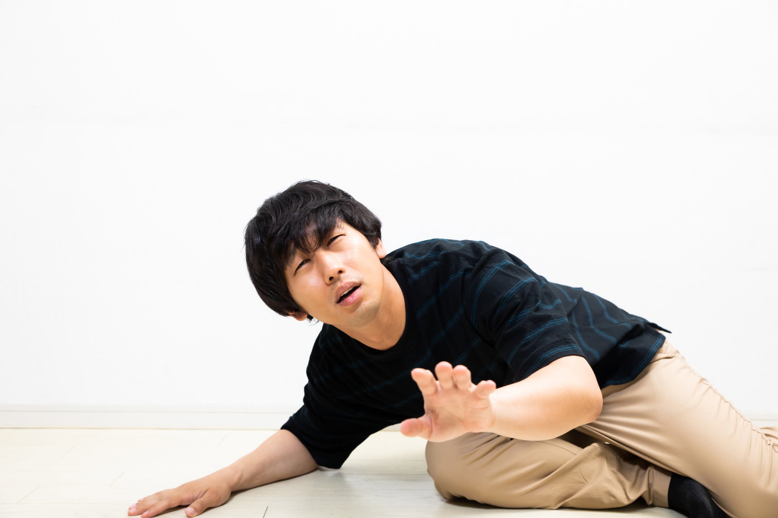 床に這いつくばって許しを請うポーズをとる男性［モデル：大川竜弥］