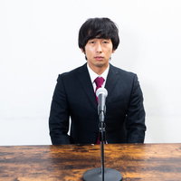 教壇で挨拶する男性（記者会見）の写真