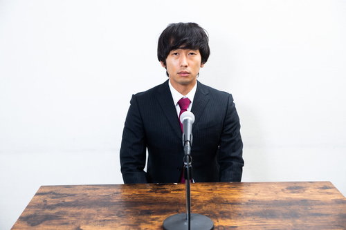 教壇で挨拶する男性（記者会見）