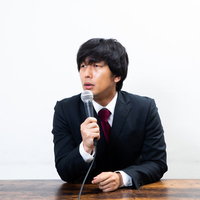 質問攻めの記者を睨みつける男性が謝罪会見で真剣に対応の写真