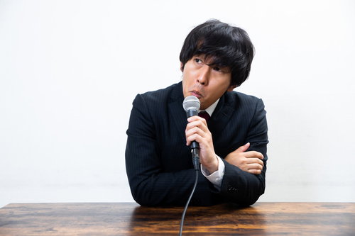 コメントを求められて渋々答える評論家の男性