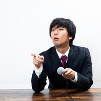 質問者に指をさして罵倒する偉そうな男性ビジネスマンの写真