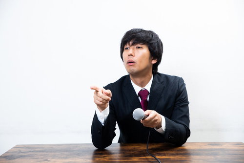 質問者に指をさして罵倒する偉そうな男性ビジネスマン