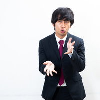 何かを説明するとき手をくねくねする会社員男性の写真