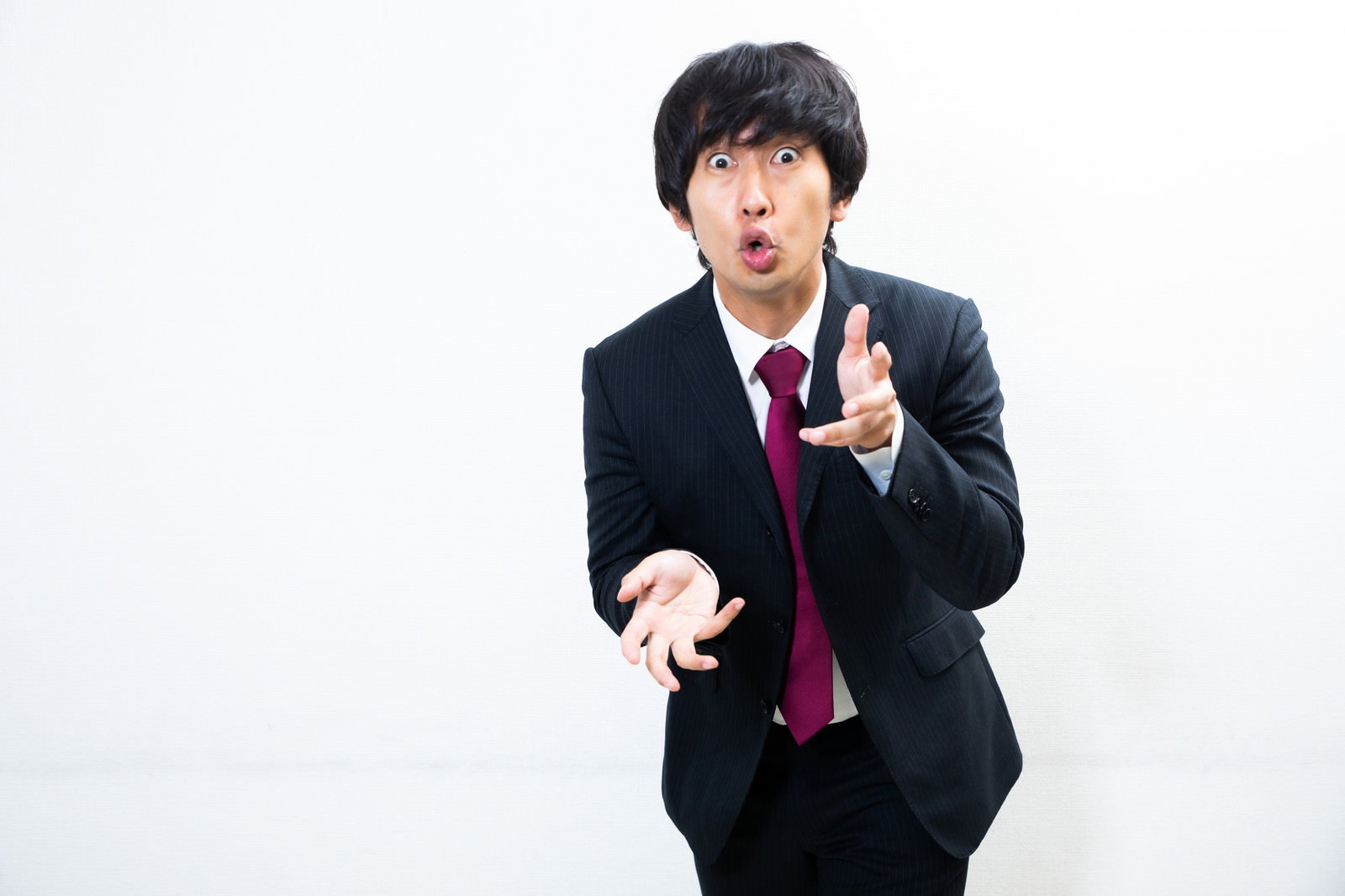 黒いスーツを着た男性が指差しながら必死に言い訳している［モデル：大川竜弥］