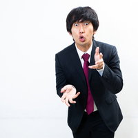 必死で言い訳をする会社員男性のジェスチャーの写真