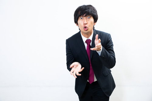 必死で言い訳をする会社員男性のジェスチャー